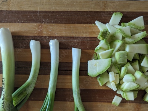 Zucchini and green onion on a chopping wooden board