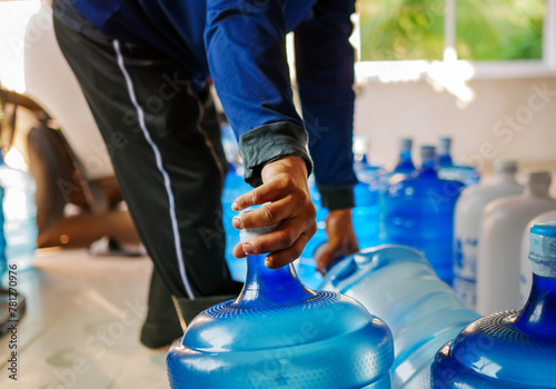 Workers lift drinking water .clear and clean in blue plastic gallon into the back of a transport truck purified drinking water inside the production line to prepare for sale. Water drink factory photo