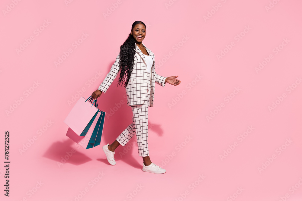 Full size profile side photo of young fancy girl walk shopping center discount isolated over pink color background Full size profile side photo of young fancy girl walk shopping center discount isolated over pink color background
