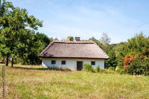 Authentic Ukrainian house in countryside. Summer village in Ukraine. Old folk thatched house. Ukrainian traditional rustic house. Rural countryside in summer ranch. Architecture farm
