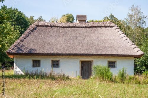 Authentic Ukrainian house in countryside. Summer village in Ukraine. Old folk thatched house. Ukrainian traditional rustic house. Rural countryside in summer ranch. Architecture. Old school