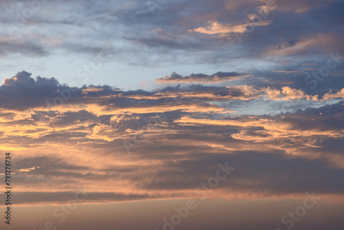 Layered clouds at sunset display a rich tapestry of gold and lavender hues, offering a majestic backdrop perfect for artistic endeavors and sky replacements © Artem