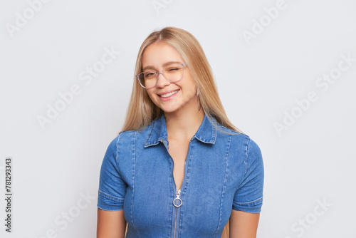 The young woman with glasses and blue dress shirt is smiling