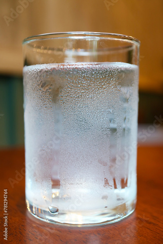 Closeup of a glass of cold water isolated on wooden table