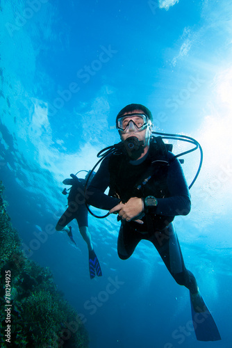 Scuba diver with sun beams rays and sun shine underwater.

