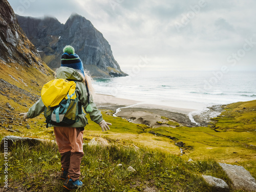 Child traveler hiking to Kvalvika beach in Lofoten islands travel family vacations in Norway outdoor activity healthy lifestyle 4 years old kid with backpack soaking in the ocean view © EVERST