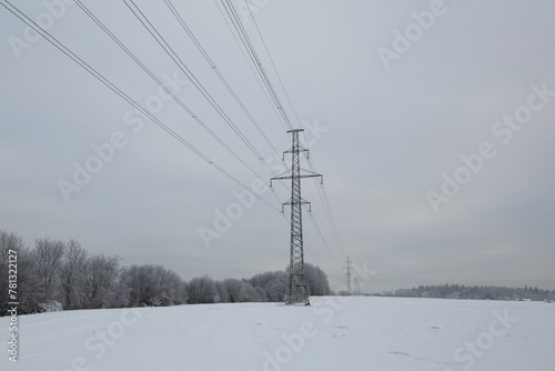 Electricity pylon against cloudy sky in winter with snow on the ground, Haltiala, Helsinki, Finland.