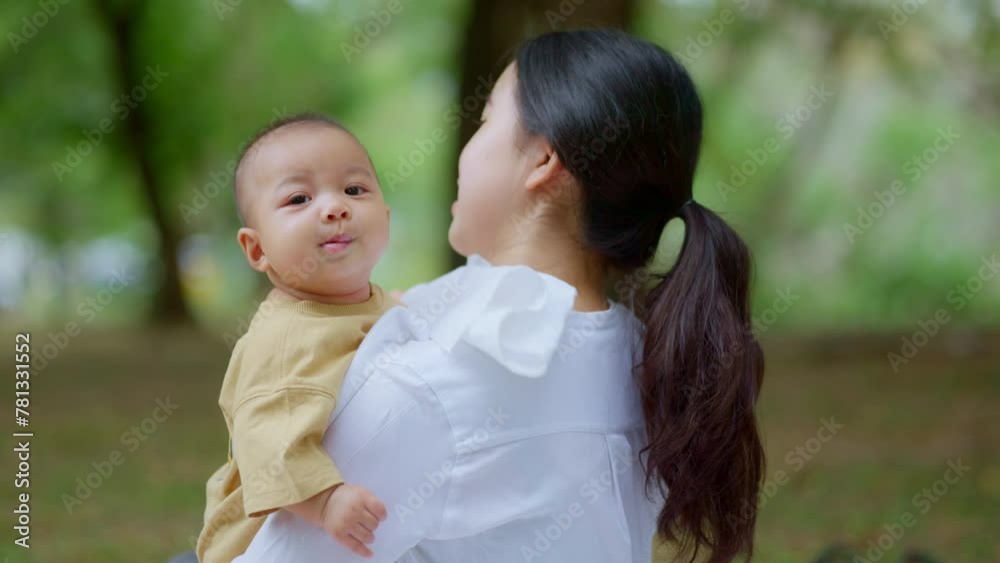 Asian mothers or single moms are smiling and hugging newborn babies. Family doing activities and relaxing in the park. Concepts about the duties of a wife and mother in raising children and family. Asian mothers or single moms are smiling and hugging newborn babies. Family doing activities and relaxing in the park. Concepts about the duties of a wife and mother in raising children and family.