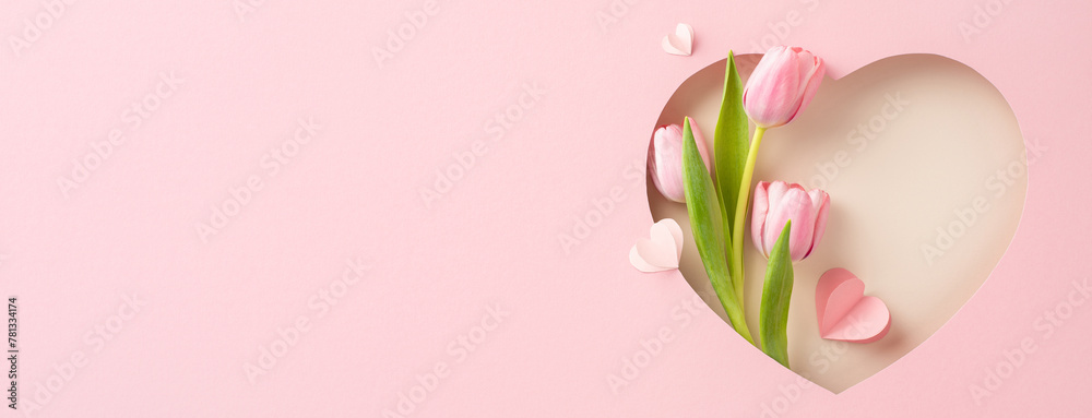 Naklejka premium Chic Mother's Day vision: Top-view shot of tulips, and paper hearts within a heart-shaped frame against pastel pink. Ideal for messages or promotions