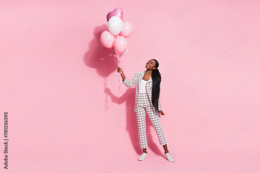 Full length photo of young cheerful girl look inflate balls decor event festive isolated over pink color background Full length photo of young cheerful girl look inflate balls decor event festive isolated over pink color background