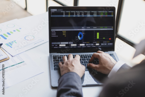 Businessman working with laptop is analyzing business finance and investment data.