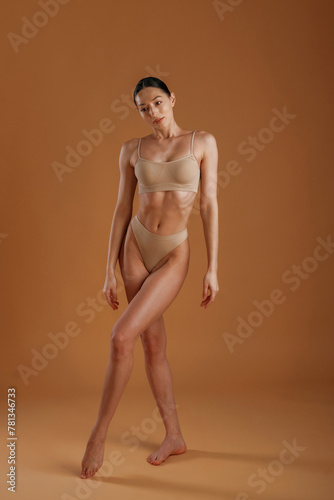 Beautiful model. Woman with slim body shape is posing against background