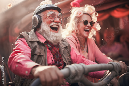 Fun elderly couple riding bumper cars at fun fair