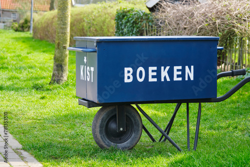 Dutch free mini public neighbourhood library where you can borrow and deliver books on a wheelbarrow with text boeken kist. This translates to book box in english.	