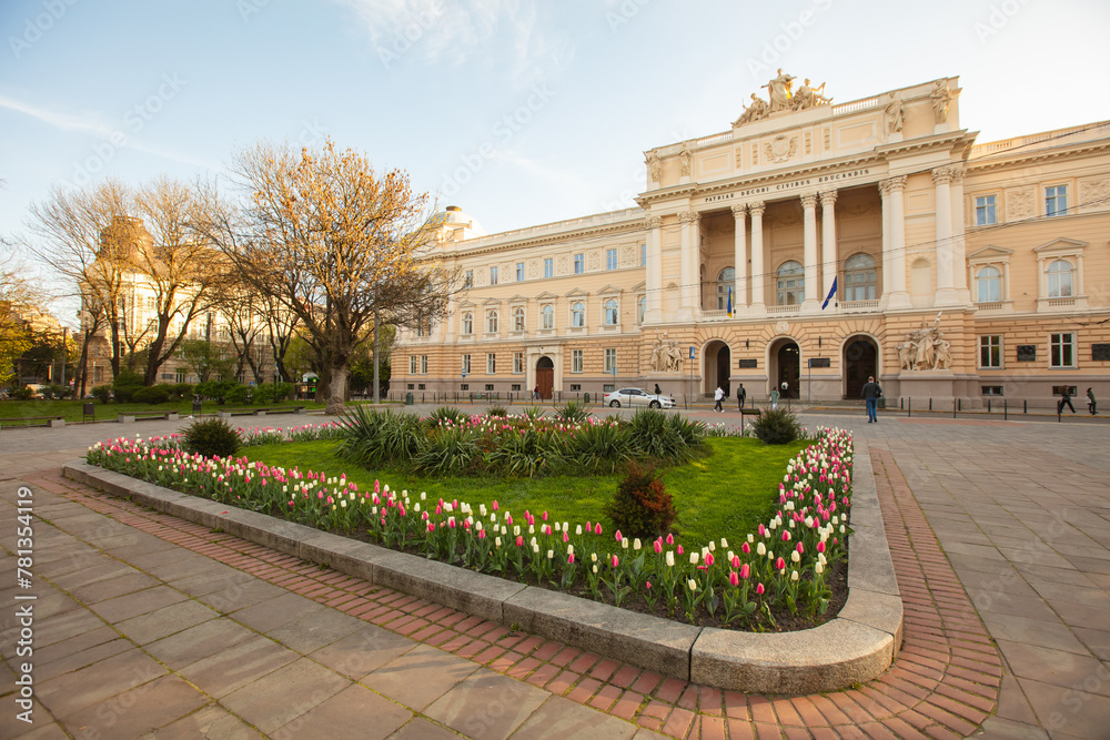 Fototapeta premium Flowerbed with tulips in front of Ivan Franko National University of Lviv