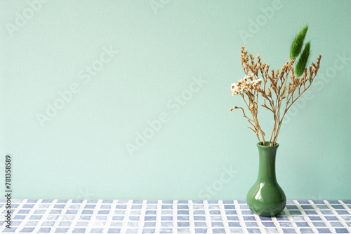 Obraz na płótnie Green vase of dry flower on blue tile table. mint wall background w salonie