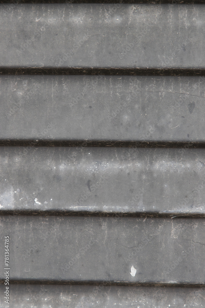 Detail of a metal door with recesses painted gray and dirty with dust. Background image