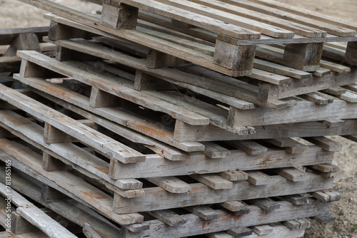 Background of old wooden pallets stacked on top of each other in outdoor environment. Close up