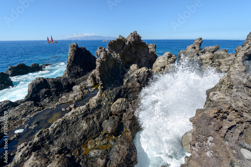 Ocean wave among volcanogenic rocks of cape Barbero, Tenerife, Canary.