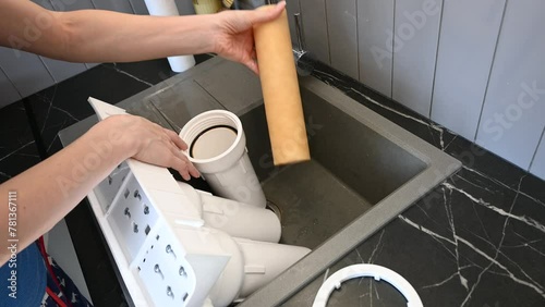 Woman installing water filter cartridges in a kitchen. Installation of water purification system