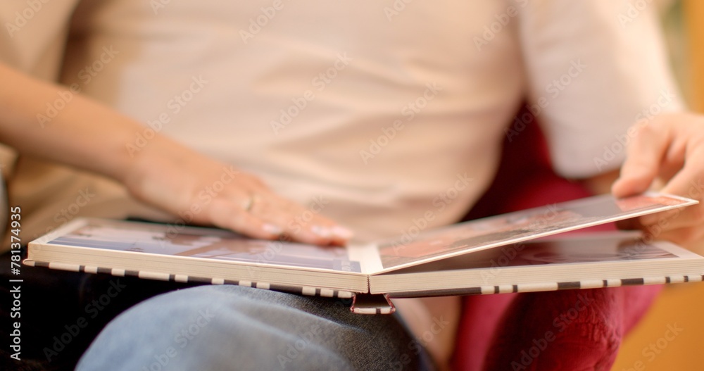 Close-up people flips through a book with photos. Male and female hands close-up. Engrossed in reading, enjoys a moment of relaxation and leisure in the comfort. Photo books as Collection of Memories 