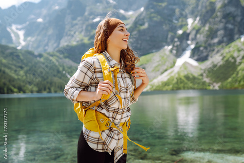 Happy woman feeling happy among amazing mountains, forest and lake, enjoy the nature landscape. Lifestyle, traveler, nature, active life. © maxbelchenko