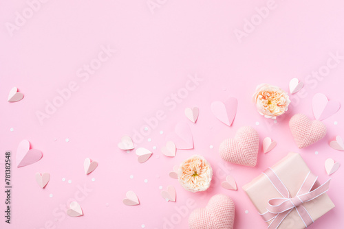 Fototapeta Naklejka Na Ścianę i Meble -  Gift or present, rose flowers and decorative hearts on pink background top view. Birthday, Woman or Mothers Day greeting card.