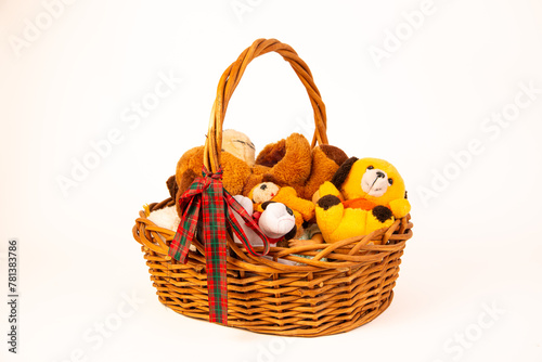 Woven basket with handle full of stuffed animals on a white background.