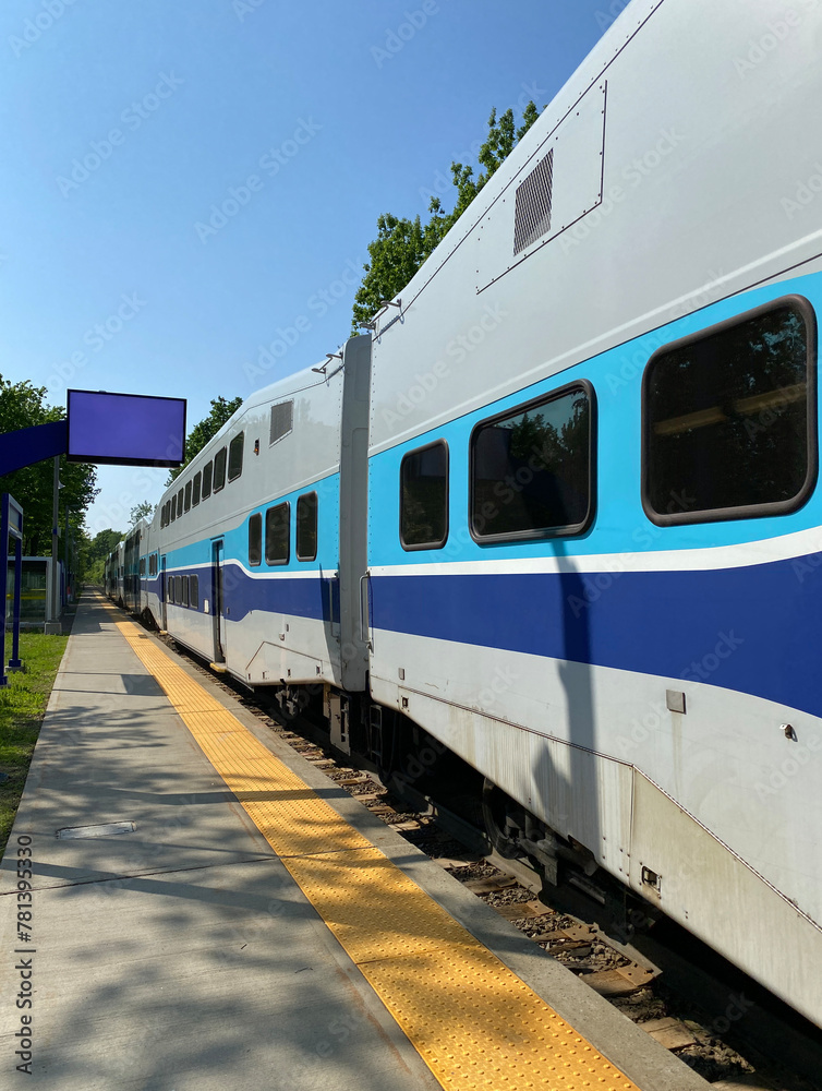City train at the station ready for departure. Close up of wagons and windows of a suburban train at the boarding platform. Display panel for travel times.
