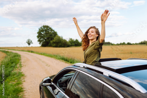 Pretty woman resting and enjoying travel out of the car window. Lifestyle, weekend, tourism, nature, active life.