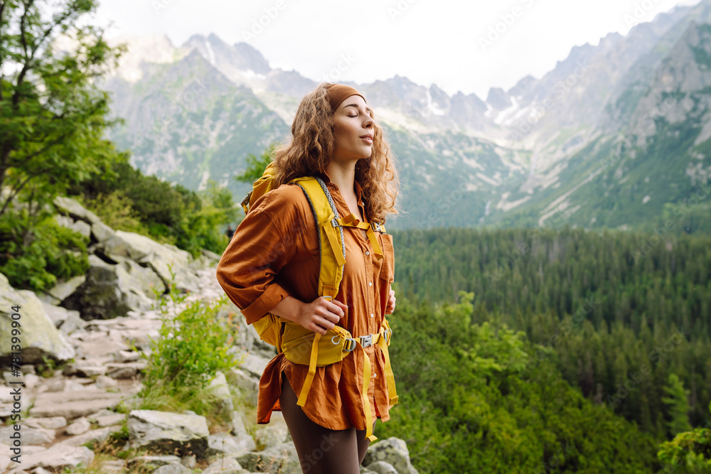 Woman traveler enjoying beautiful view of mountains. Beautiful mountains landscape view. Lifestyle, adventure, nature, active life.