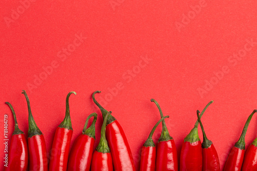 Red hot chilli peppers on minimal red background