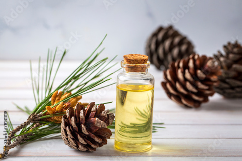 Pine turpentine essential oil in glass bottle with pine coniferous leaves and pine cone. Kiefer turpentin photo
