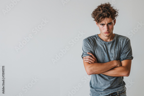 Jeune homme triste les bras croisés regardant le sol, espace pour texte