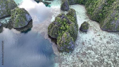 Healthy coral reefs surround islands rising from Raja Ampat's tropical seascape. This region of Indonesia is known as the heart of the Coral Triangle due to the marine biodiversity found there.