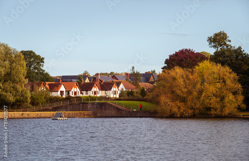 A landscape with freshwater and residential area on lakeside in Autumn colours