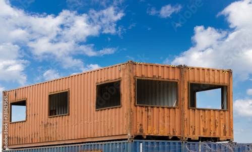 A rusty steel ocean shipping container converted to an industrial site office