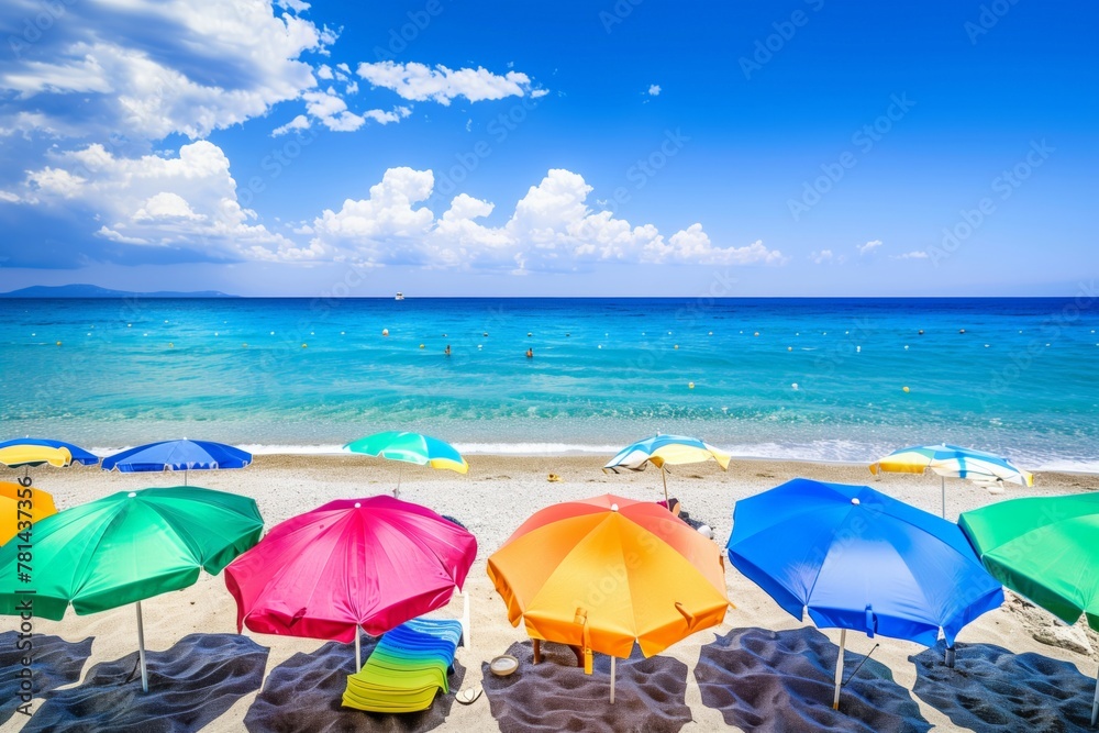 A beach scene with many colorful umbrellas and chairs. Scene is cheerful and inviting, as it seems like a perfect day for a relaxing beach outing
