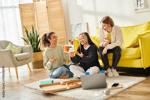 A diverse group of teenage girls sitting on the floor, enjoying pizza together in a cozy home setting.