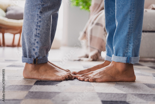 Cropped photo of nice young man girl kiss feet legs modern interior indoors cozy daylight apartment living room