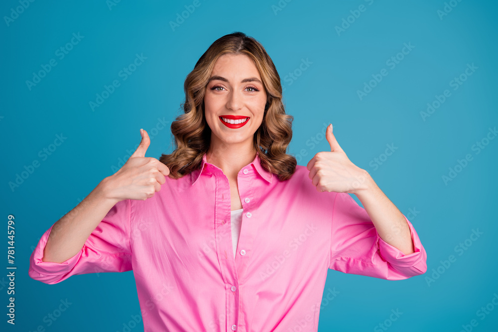 Photo portrait of pretty young girl thumb up good quality wear trendy pink outfit hairdo isolated on blue color background