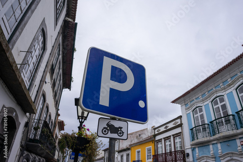 Fototapeta Naklejka Na Ścianę i Meble -  Motorcycle parking sign against a vibrant urban backdrop. Perfect for illustrating designated parking areas in cityscapes.
