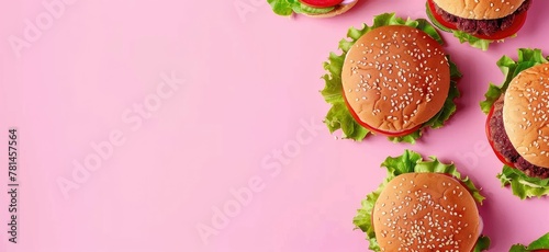 A creative display of vegetarian burgers with fresh ingredients on a striking pink background, inviting a healthy lifestyle.