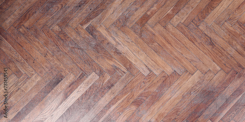 Detailed view of herringbone pattern wooden parquet floor with rich textures and tones. Classic elegance and craftsmanship in interior design highlighted by natural wood
