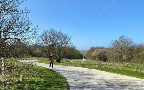 person walking on a path to the sea