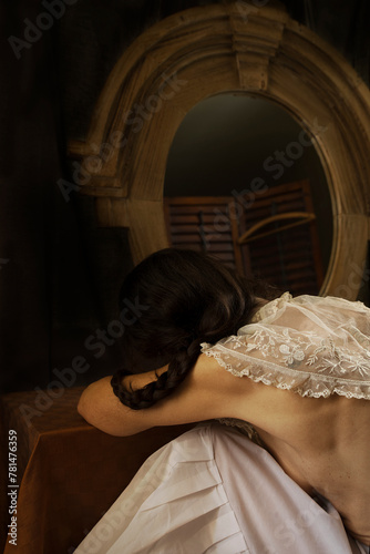 woman from behind with braid leaning on a dressing table VI