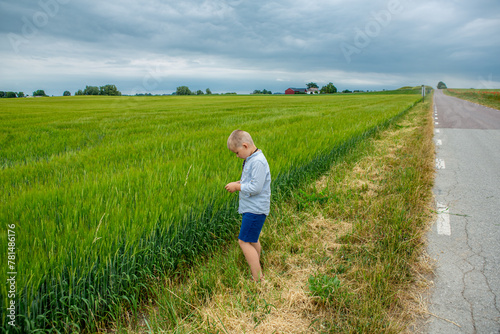 Boy by green field in south Sweden