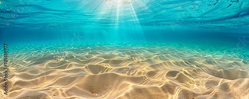 Clear underwater seascape with sunbeams illuminating sand ripples on the ocean floor photo