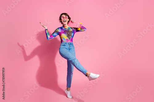 Full size photo of nice young woman skateboard empty space wear pullover isolated on pink color background © deagreez