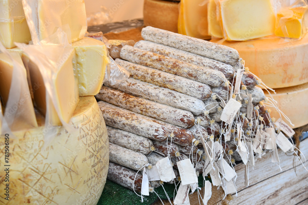 Farm stall with cheese wheels and smoked sausage at the fair